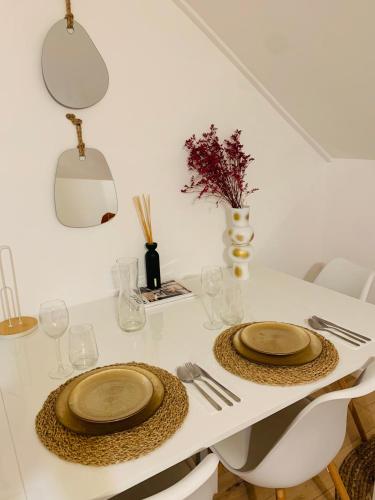 une table blanche avec deux plaques au-dessus dans l'établissement Le Bora Cosy House - T2 lumineux et moderne à proximité du métro, à Maisons-Alfort