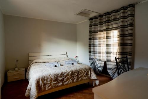1 dormitorio con cama y ventana grande en Domus Teja, en Agira