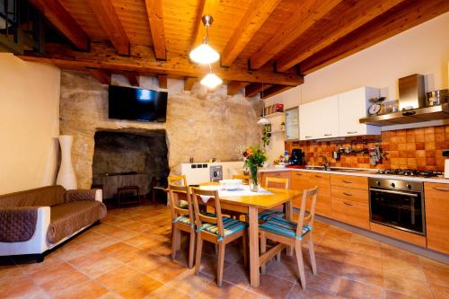 een keuken met een tafel en stoelen en een bank bij Domus Teja in Agira