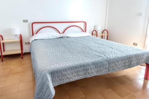 una camera da letto con un letto con un piumone blu di Comodo bilocale a Marcelli - M271 a Marcelli