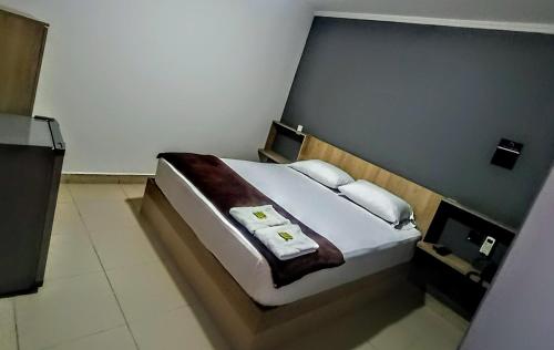 a bedroom with a large bed with two towels on it at Hotel Ruiseñor Itagui in Itagüí