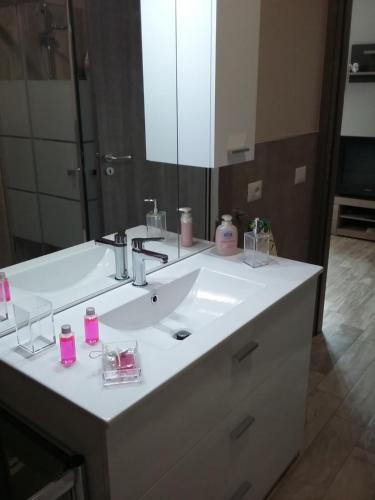 a bathroom with a white sink and a mirror at DA ISINOE in Mascali