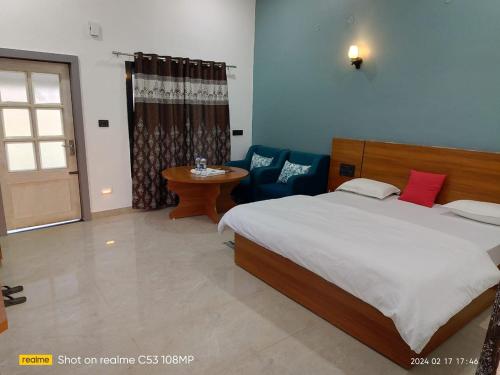 1 dormitorio con 1 cama, 1 silla y 1 mesa en Singanama RESORT, en Pachmarhī