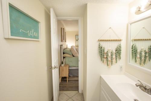 a bathroom with a sink and a room with a bed at Waters Edge in Myrtle Beach