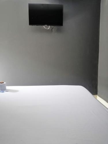 a bedroom with a white bed and a flat screen tv at Hotel La Mata in La Mata