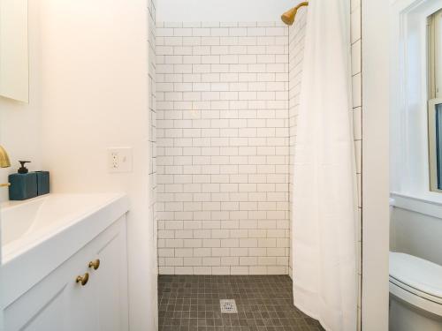 een witte badkamer met een douche en een toilet bij Highfall Hideaway Your Cozy Escapetvpetswi-fi in Rochester