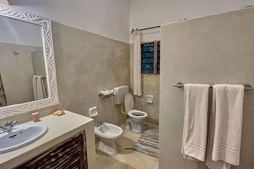 a bathroom with a sink and a toilet and a mirror at Villa Marine Park - Malindi in Malindi
