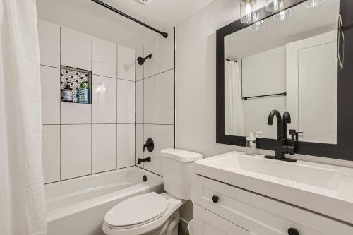 a white bathroom with a toilet and a sink at Lush 2bd In Heart Of Tempe Near Beachparkdtwifi in Tempe