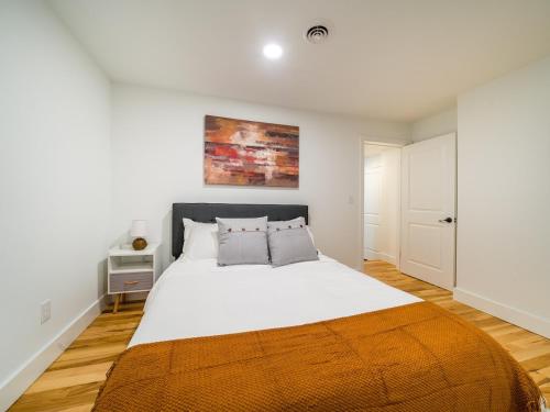 - une chambre avec un grand lit blanc et une couverture orange dans l'établissement Cornhill1bed-cozyequipkitchentvwi-fihighfalls, à Rochester