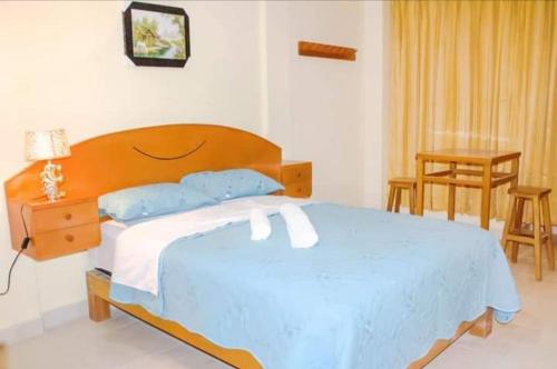 1 dormitorio con 1 cama grande y cabecero de madera en Dominius Hotel, en Olmos