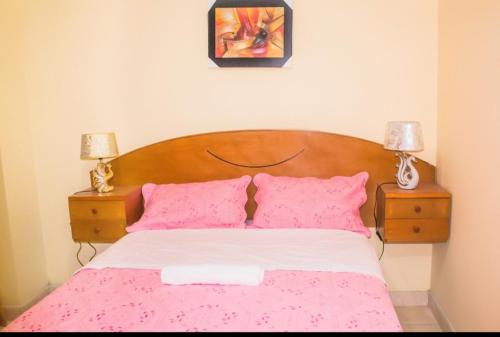 1 dormitorio con 1 cama con sábanas y almohadas rosas en Dominius Hotel, en Olmos