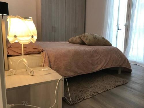 una camera da letto con un letto e una lampada su un tavolo di VILLA BRIANZA A TAGLIATA DI CERVIA 30 MT MARE a Cervia