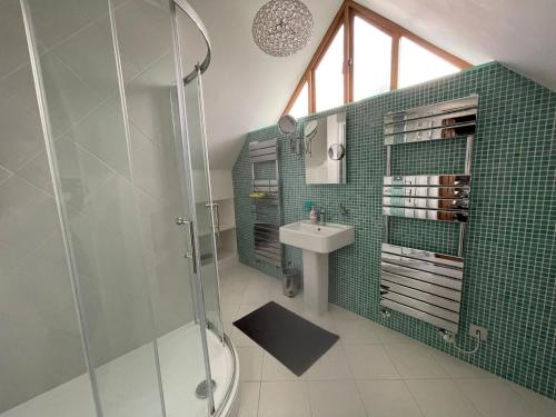 a bathroom with a glass shower and a sink at Little Kent End Cottage in Ashton Keynes
