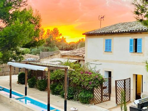 a house with a gazebo in front of a sunset at Finca Sa Canova Agroturismo in Campos