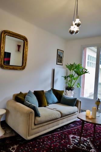 a living room with a couch and a mirror at Maison au cœur des vignes in Épernay
