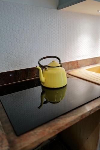 a yellow tea pot sitting on top of a counter at Maison au cœur des vignes in Épernay