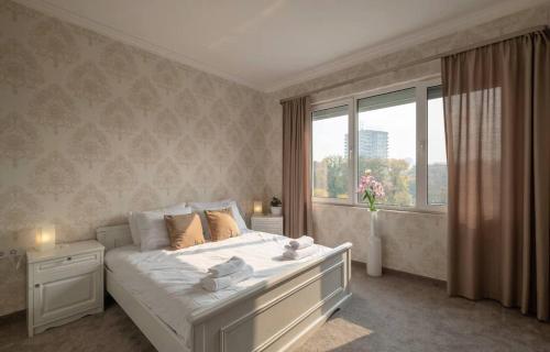 a bedroom with a large white bed with a window at Amazing Location In The Center For 8 in Sofia