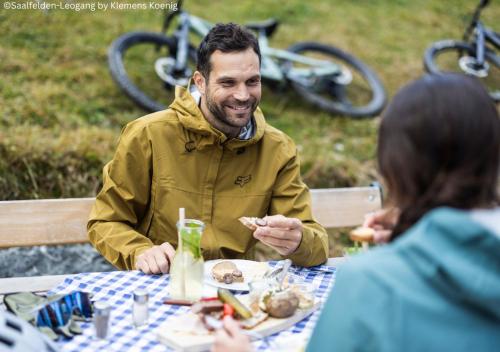 een man aan een tafel eten bij Appartements Kuckuck Leogang in Leogang