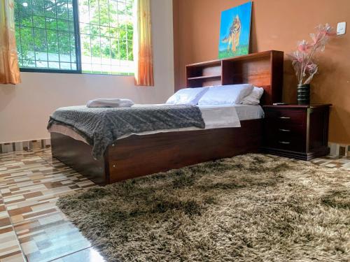 1 dormitorio con 1 cama grande y 1 alfombra en Hostería Chambira, en Puerto Francisco de Orellana