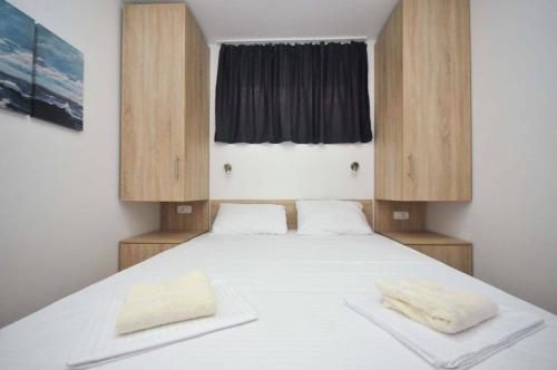 a bedroom with a bed with two towels on it at Apartments M Čanj in Čanj