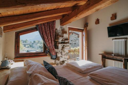 1 dormitorio con cama y ventana en Au coeur du village Chambes d'hôtes & SPA, en Arnad