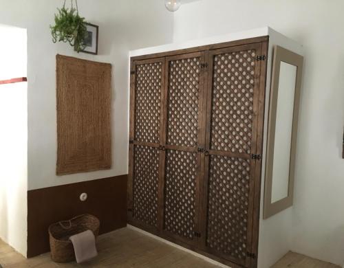 a wooden cabinet in a room with a mirror at Casa Del Fogón, En La Calle Del Castillo in Vejer de la Frontera