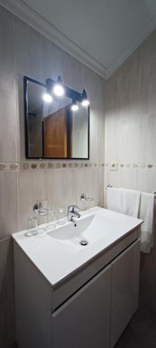a bathroom with a white sink and a mirror at Residencialusobrasileira in Leça da Palmeira
