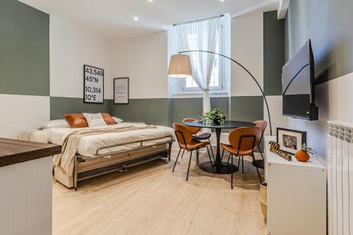 Schlafzimmer mit einem Bett und einem Tisch mit Stühlen in der Unterkunft Discover Apartment in Livorno