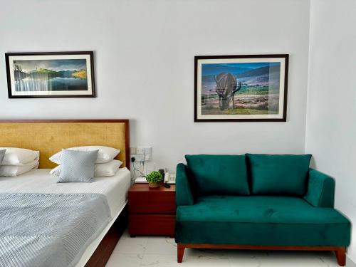 ネゴンボにあるOcean Breeze Hotel Residencies BritLanka Apartments Negomboのベッドルーム1室(ベッド1台、緑の椅子付)