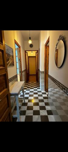 Pokój z podłogą wyłożoną szachownicą, stołem i lustrem w obiekcie Casa Cervantes w Grenadzie
