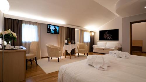 Habitación de hotel con cama y sala de estar. en Golf Club Padova - Relais Graya, en Galzignano Terme