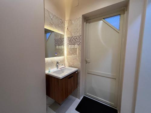 a bathroom with a sink and a window and a door at بوتيك هاوس بتصاميم مميزة وأنيقة in Hail