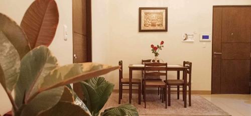 a dining room table and chairs with a vase of flowers at Unit 3J Signature Suites, Lafayette Megaworld in Iloilo City