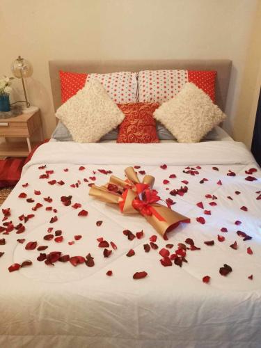 a bed with flower petals laying on it at Unit 3J Signature Suites, Lafayette Megaworld in Iloilo City