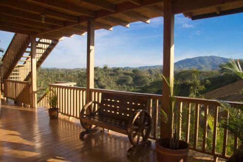 a bench on a porch with a view of the mountains at Villas Las Neblinas in Constanza