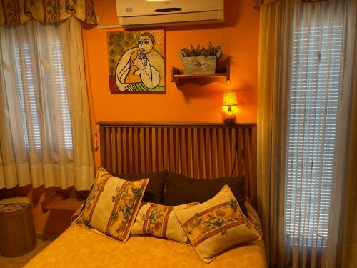 a bedroom with orange walls and a bed with pillows at Chiki in Peniscola