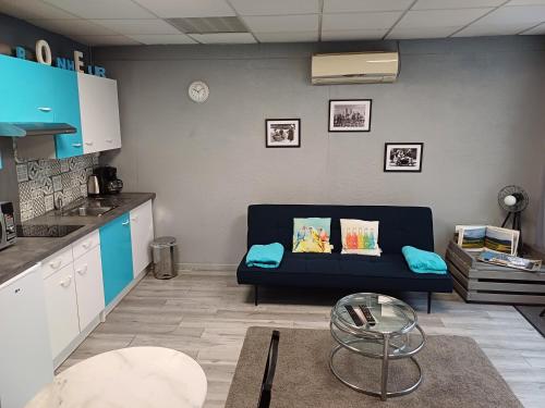 a living room with a blue couch in a kitchen at Au Coup de Cœur in Colmar