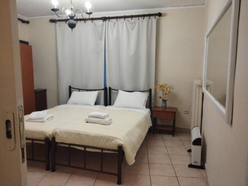 um quarto com 2 camas e toalhas em Corfu Aegli appartments em (( Filaréton ))