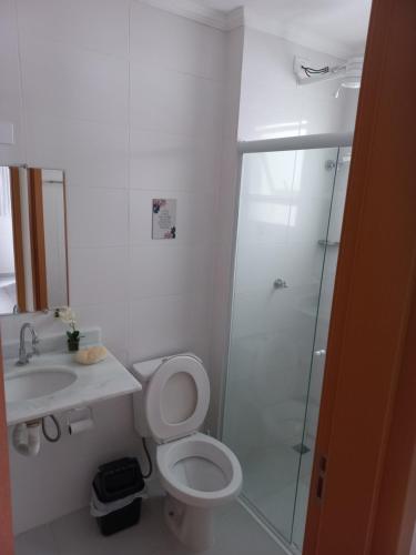 y baño con ducha, aseo y lavamanos. en Apartamento para 6 pessoas bairro pereque mirim, en Ubatuba