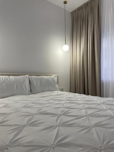 a bedroom with a large white bed and a window at Neutral Nest in Sibiu