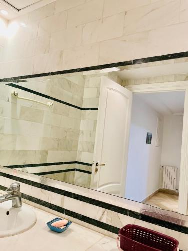baño con espejo y lavabo en Superbe villa meublée Ennacer 95€/j en Burj at Turkī