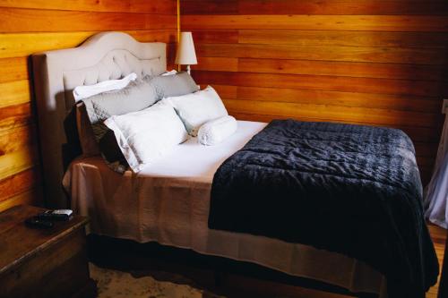 a bedroom with a large bed with wooden walls at Green Valley Refuge in Urubici