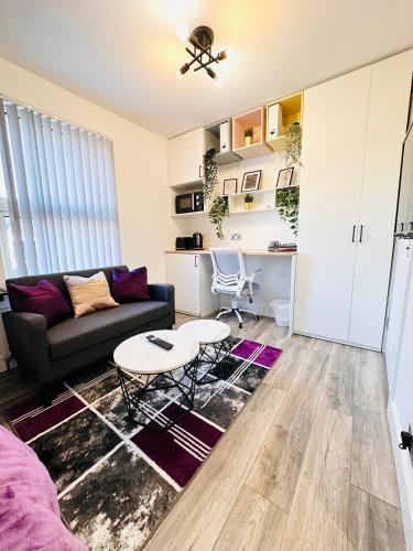 a living room with a couch and a table at Newly renovated luxury Private En-Suite Room in Harborne Park Road - Birmingham R3 in Birmingham
