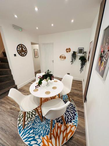 a dining room with a white table and chairs at Newly renovated luxury Private En-Suite Room in Harborne Park Road - Birmingham R3 in Birmingham