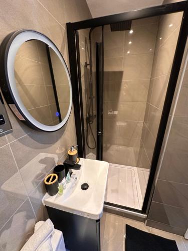 a bathroom with a shower and a sink and a mirror at Newly renovated luxury Private En-Suite Room in Harborne Park Road - Birmingham R3 in Birmingham