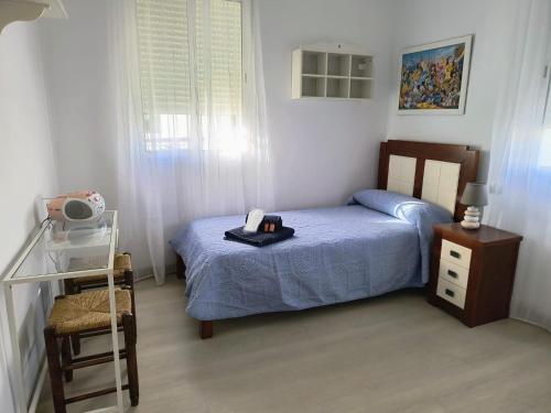 małą sypialnię z łóżkiem i szafką nocną w obiekcie Casa El limonero w Sewilli