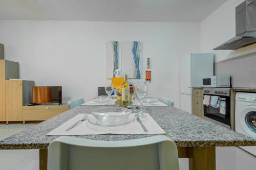 a kitchen with a table with wine glasses on it at CityScape Gzira Holiday Apartments and Penthouse in Il-Gżira