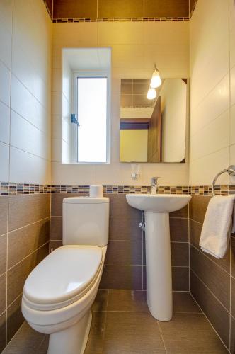 a bathroom with a toilet and a sink at CityScape Gzira Holiday Apartments and Penthouse in Il-Gżira