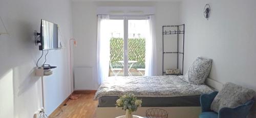 ein Schlafzimmer mit einem Bett und ein Wohnzimmer in der Unterkunft Petite touche douceur - studio avec parking et terrasse in Suresnes