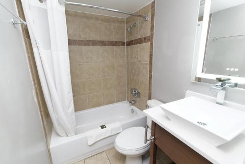 a bathroom with a tub and a toilet and a sink at Oceans 2700 in Virginia Beach